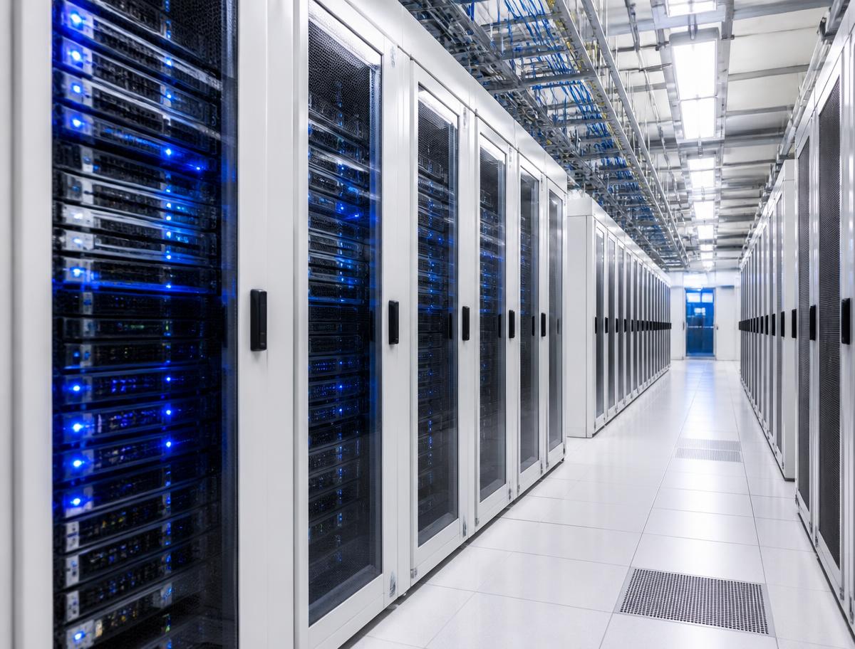 Aisle of server racks with blue status indicators inside a modern data centre